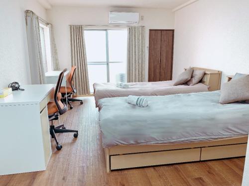 1 dormitorio con 2 camas, escritorio y sofá cama en 匯金上板橋ビル, en Tokio