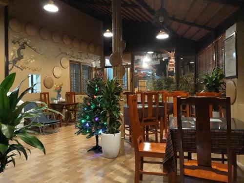 a restaurant with a table and chairs and a christmas tree at An Phu's Garden House in Ninh Binh