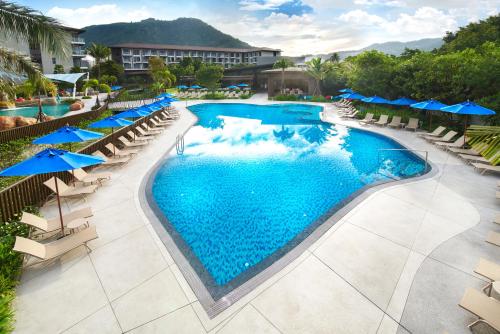 an overhead view of a swimming pool with chairs and umbrellas at OZO Phuket in Kata Beach