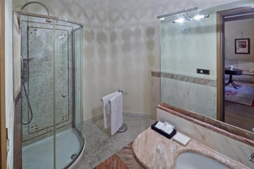 a bathroom with a glass shower and a sink at Albergo Cappello in Ravenna