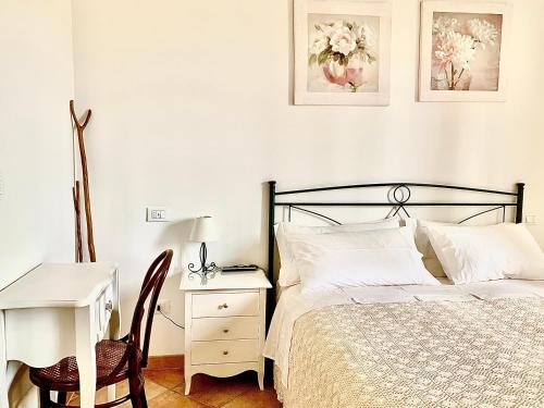 a bedroom with a bed and a desk and a table at B&B All'ombra degli ulivi in Ostuni