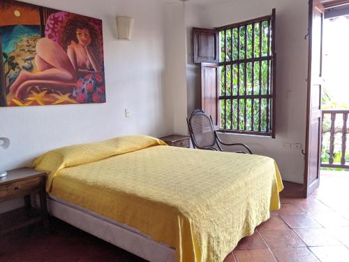 a bedroom with a bed and a painting on the wall at Casa Digna in Cartagena de Indias