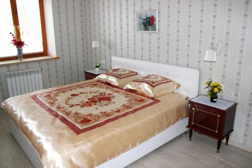 ヨシュカル・オラにあるLuxury Apartment in Yoshkar-Ola (2-rooms)のベッドルーム1室(ベッド1台、テーブル、ナイトスタンド付)