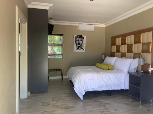 a bedroom with a bed with a yellow pillow on it at La Fiato Luxury Lodge in Dalmada AH
