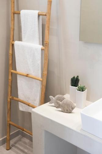 a towel rack with towels on top of a bathroom counter at White Orchid Suites in Vóthon