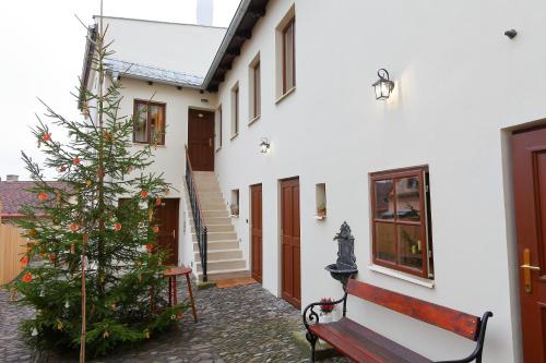 a building with a bench and a christmas tree at Lucerna - dům s duší Příbor in Příbor