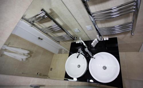La salle de bains est pourvue d'un lavabo blanc et d'un miroir. dans l'établissement AlmaBagi Hotel&Villas, à Quba