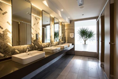 a bathroom with three sinks and a large window at Swiss-Garden Hotel & Residences, Genting Highlands in Genting Highlands