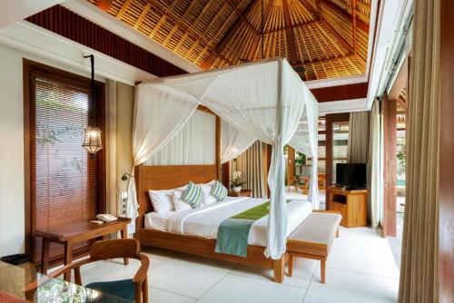 a bedroom with a bed with a canopy at Regali Villa Canggu in Canggu