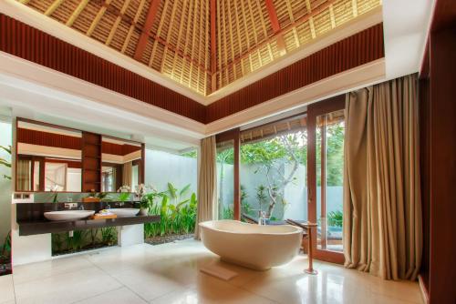 a bathroom with a large tub and two sinks at Regali Villa Canggu in Canggu