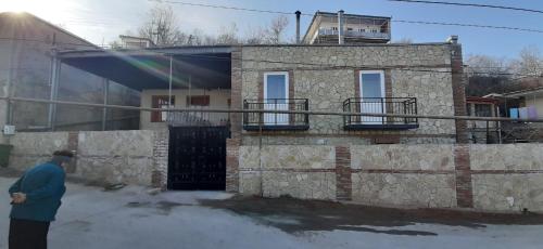 a man standing in front of a stone house at Goga Guesthouse in Sighnaghi