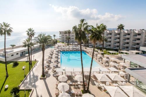 an aerial view of a resort with a swimming pool and palm trees at Hotel Garbi Ibiza & Spa in Playa d'en Bossa