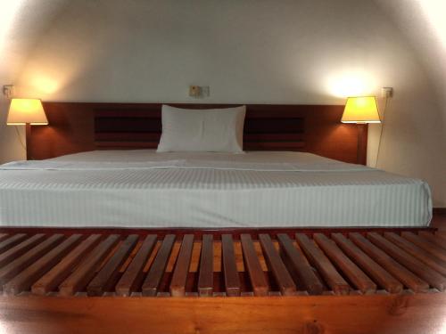 a bedroom with a large bed with two lamps at The Rock House in Katunayake