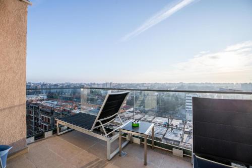 a balcony with a chair and a table on a building at Luxury Westpark 2 Residence with Lake View in Bucharest