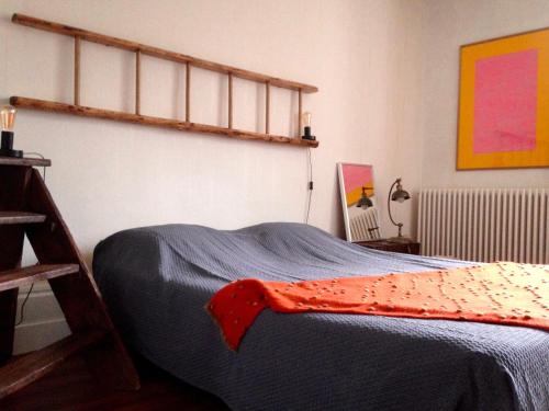 1 dormitorio con 1 cama con manta azul en Maison Les greniers, en Myon