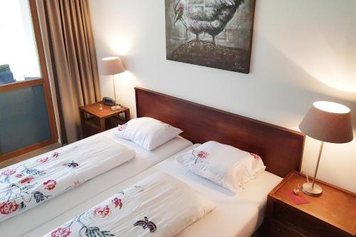 2 Betten in einem Hotelzimmer mit weißer Bettwäsche in der Unterkunft Ferienwohnung Resort Walensee 98 - Seehöckli in Quarten