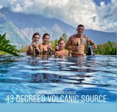 a group of people standing in a swimming pool at Batur Volcano Guesthouse in Kintamani