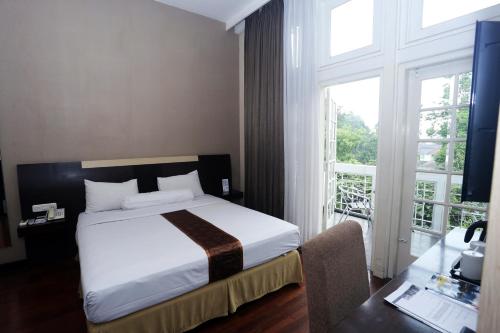 a bedroom with a bed and a large window at Vio Hotel Cimanuk Bandung in Bandung