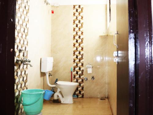 a bathroom with a toilet and a bucket in it at Shivalik River Retreat in Almora