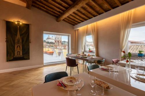 ein Esszimmer mit Tischen und Stühlen und einem großen Fenster in der Unterkunft Poēsis Experience Hotel in Rom