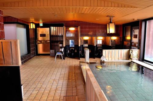 a large swimming pool in a building with a pool at Dormy Inn Hirosaki in Hirosaki