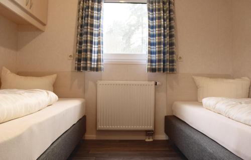 two beds in a room with a window and a radiator at M13 Hotel in Riol