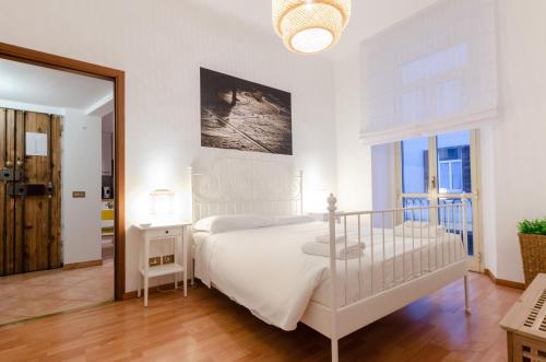 um quarto branco com uma cama e um espelho em Cozy Central Flat - Porta Romana - Duomo em Milão