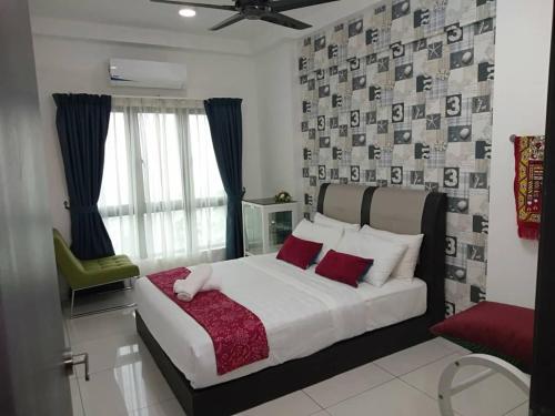 ein Schlafzimmer mit einem großen Bett und einem grünen Stuhl in der Unterkunft Luxury Homestay at Emira Residence in Shah Alam