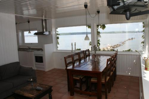 a dining room with a table and a view of the water at Loff Holiday Houses in Aabenraa