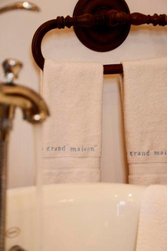 two towels are hanging on a wall next to a sink at Saint Victor La Grand' Maison in Ingrandes