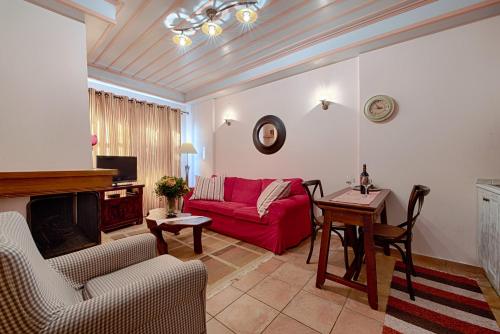 a living room with a red couch and a table at Konaki Tselepi in Arachova