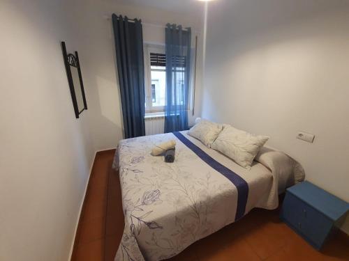 a small bedroom with a bed with blue curtains at Junto a la Plaza Mayor II in Salamanca