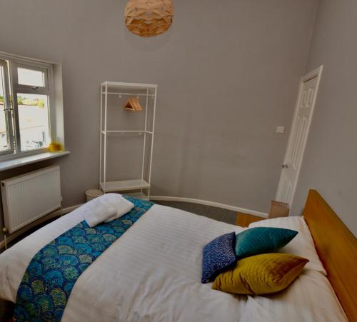 a bedroom with a bed with pillows on it at Perfect location for Racecourse and town centre in Cheltenham