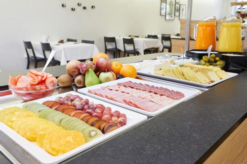 
a table topped with lots of different types of food at Kreuz Bern Modern City Hotel in Bern
