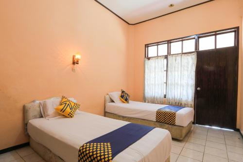 A bed or beds in a room at OYO 2465 Hotel Raung View