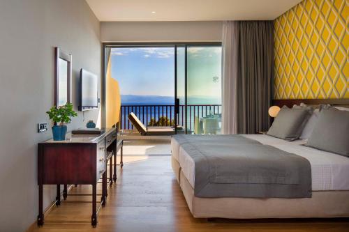 una camera con un grande letto e un balcone di Skiathos Palace Hotel a Koukounaries