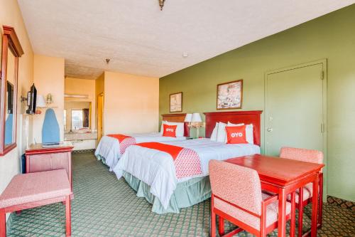 Cette chambre d'hôtel comprend deux lits, une table et des chaises. dans l'établissement OYO Hotel Grenada West, à Grenada