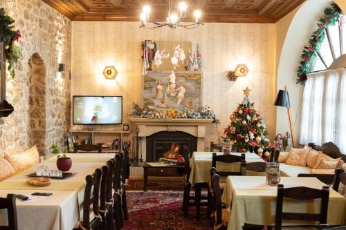 un comedor con mesas y una chimenea con un árbol de Navidad en Kaza Guesthouse, en Dhimitsana