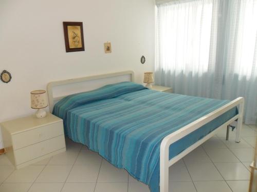 a white bedroom with a bed with a blue blanket at RIVA: TRA 5 TERRE E PORTOFINO in Sestri Levante