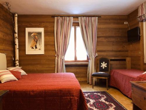 een slaapkamer met 2 bedden en een raam bij Hotel Ruitor in Arvier