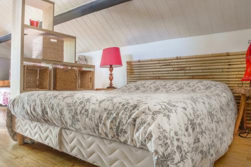 ein Schlafzimmer mit einem Bett und einer rosa Lampe in der Unterkunft Studio cosy perché dans les arbres au coeur du Périgord proche Sarlat in Castels