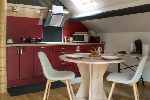 une cuisine avec une table et des chaises dans une pièce dans l'établissement Studio cosy perché dans les arbres au coeur du Périgord proche Sarlat, à Castels