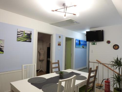 a dining room with a table and chairs and a tv at Woldo Vendégház in Töltéstava