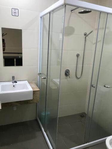 a bathroom with a shower and a sink at Island Hostel in Bayan Lepas