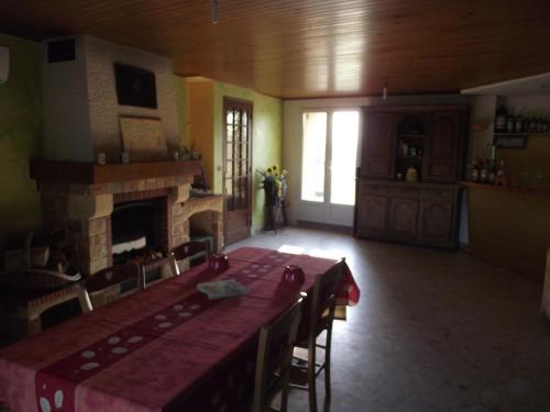 une salle à manger avec une table et une cheminée dans l'établissement Domaine des cigales, chambre d'hôtes, à Saint-Martin-dʼAoût