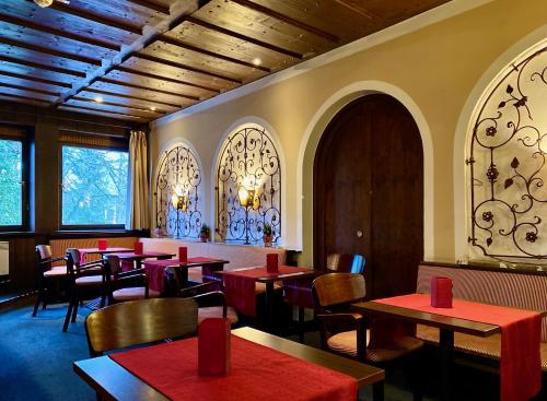 a restaurant with red tables and chairs and windows at relexa hotel Schatten Stuttgart in Stuttgart