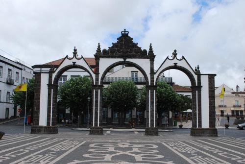 a building with three arches on a city street at Cozy Central in Ponta Delgada