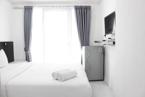 pokój hotelowy z 2 łóżkami i telewizorem w obiekcie Stylish Studio Room Grand Asia Afrika Apartment By Travelio w mieście Bandung