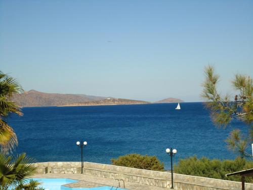 a view of the ocean with a sailboat in the distance at Vangelis Villas in Agios Nikolaos