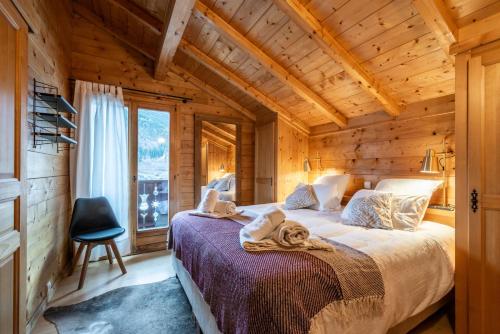 Chalet Doux Abri Morzine - by EMERALD STAY في مورزين: غرفة نوم مع سرير في كابينة خشب
